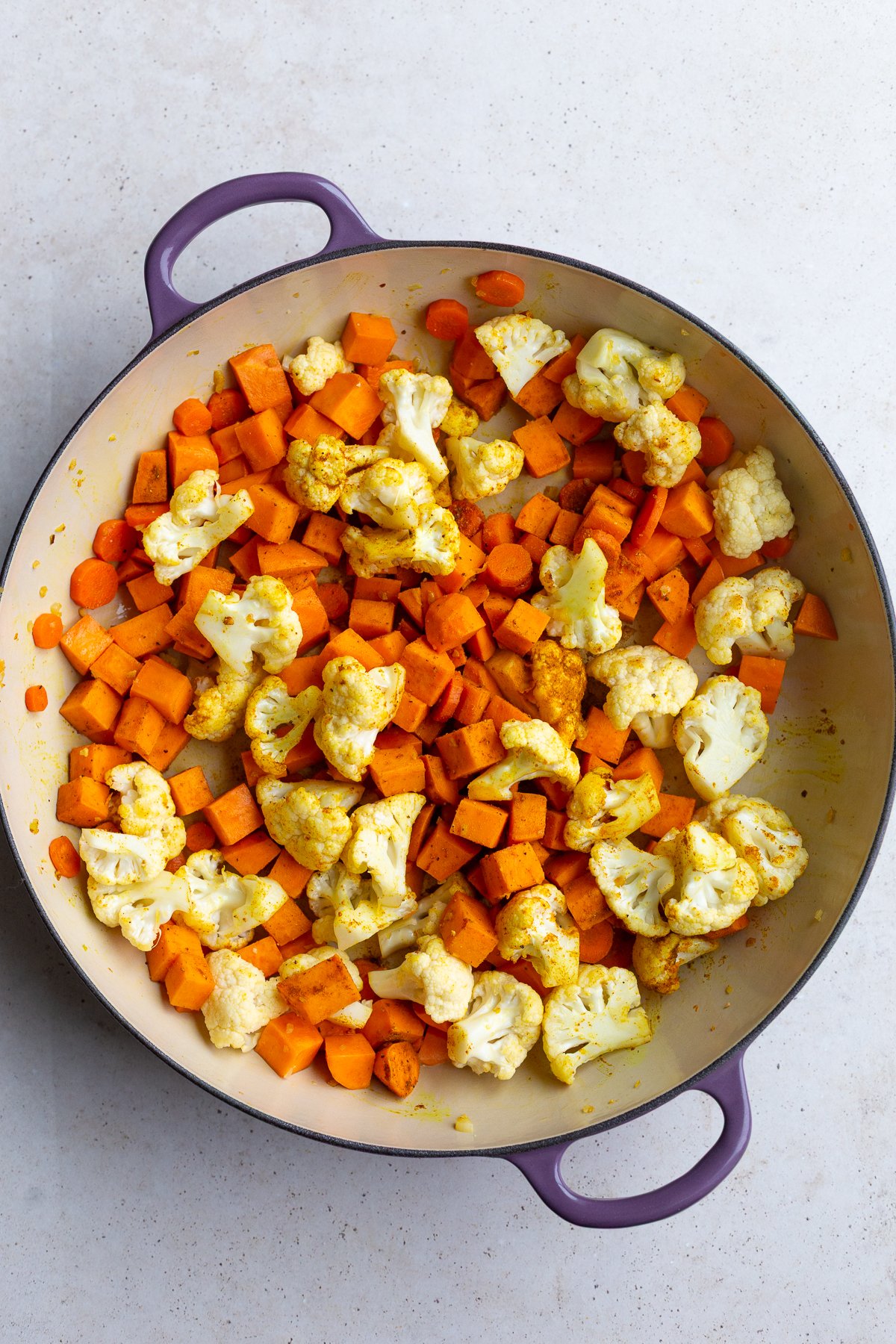 carrot, sweet potato and cauliflower in a skillet with curry powder